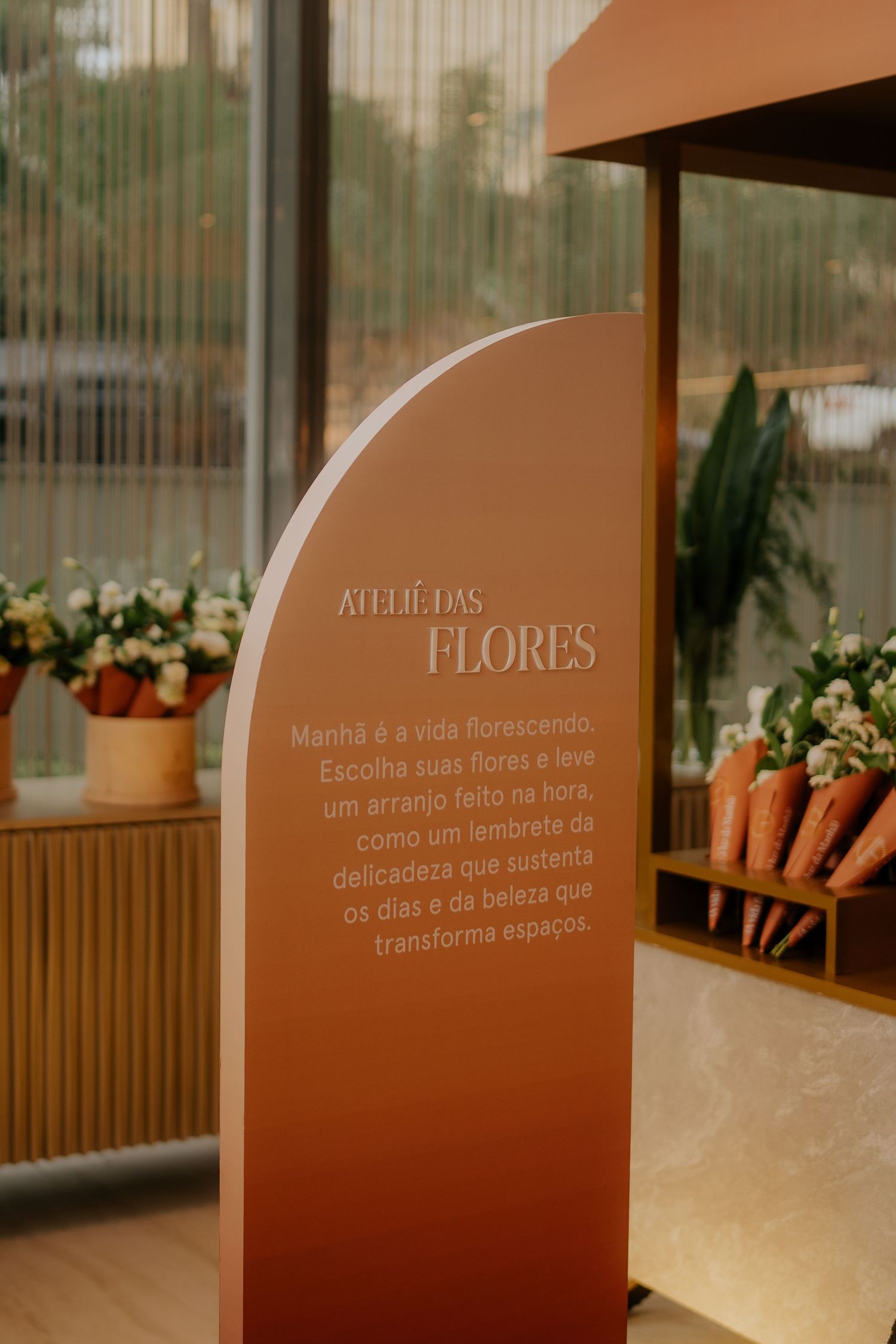 Modern interior design with curved wooden panels and text displays featuring floral arrangements and decorative carrots.