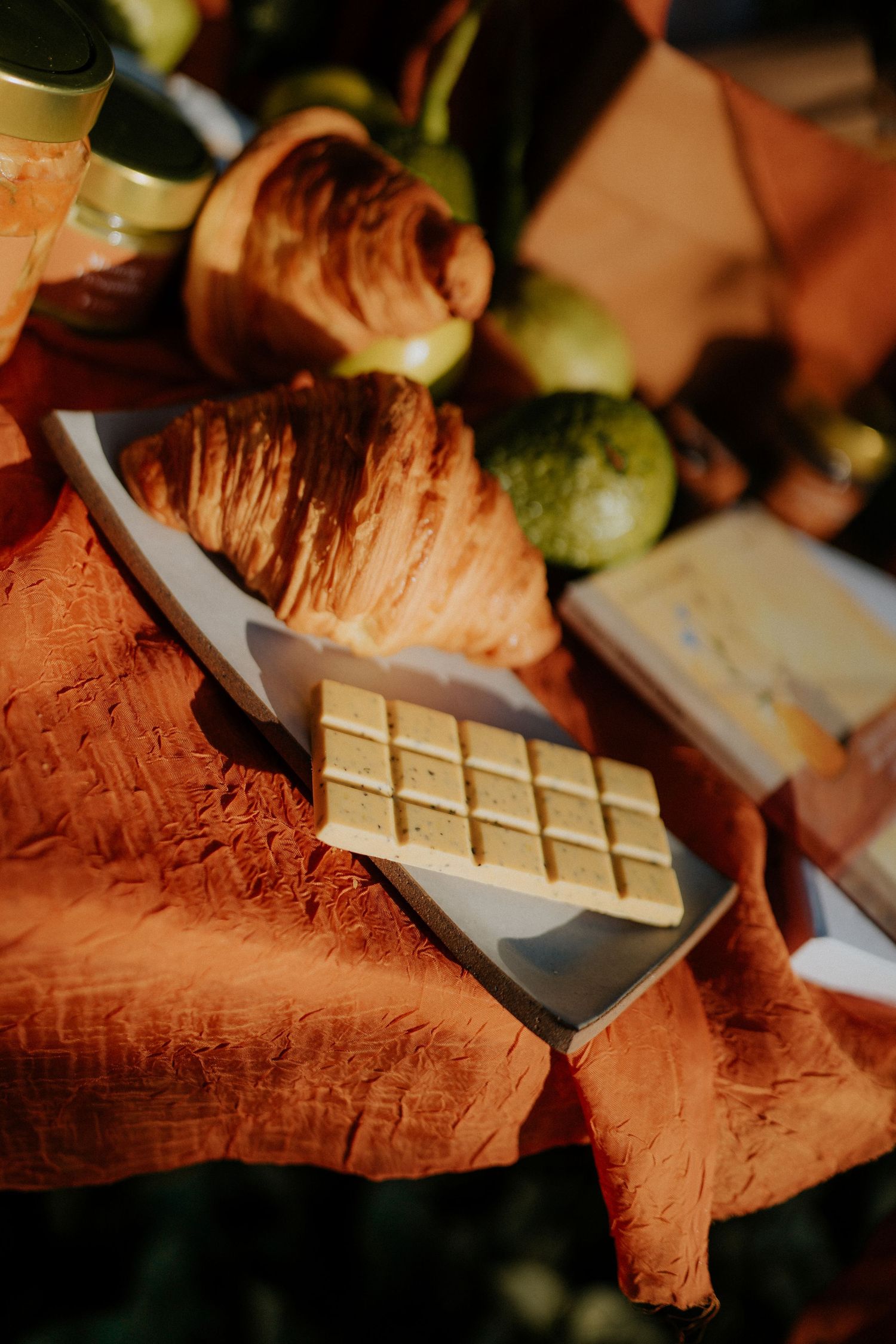 Close-up of white chocolate bars and croissants on a textured terracotta surface.