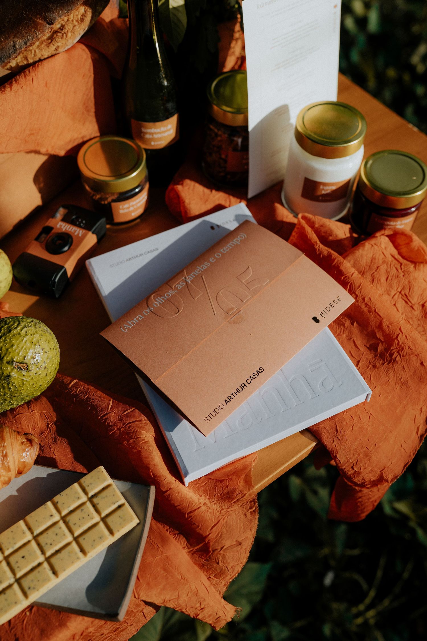 White and copper colored folders arranged with jars and snacks on a terracotta colored surface.