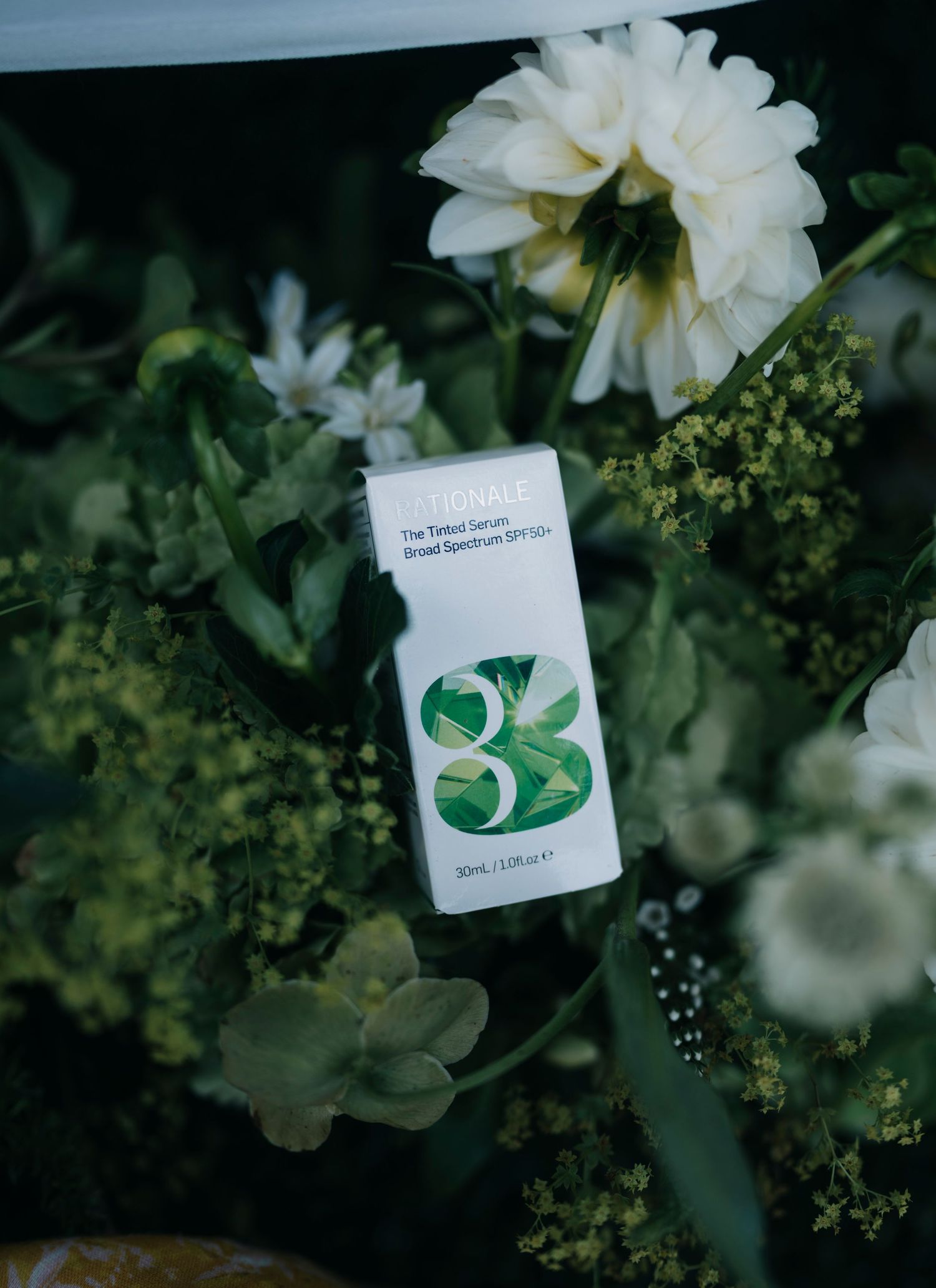 A product card displayed among white flowers and green foliage in a garden setting.