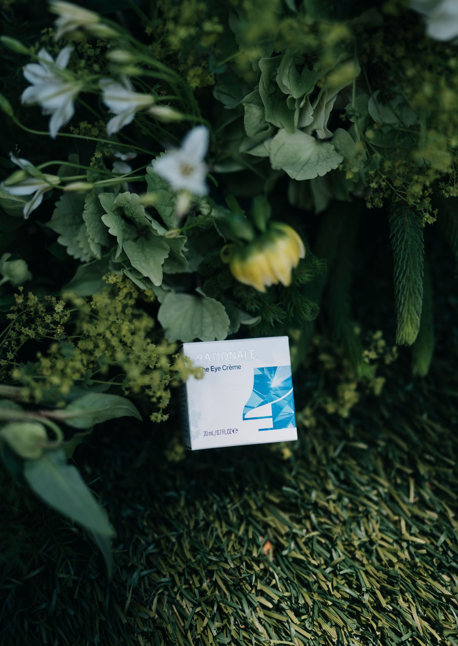 A blue-themed product card nestled in a natural arrangement of white flowers and green leaves.