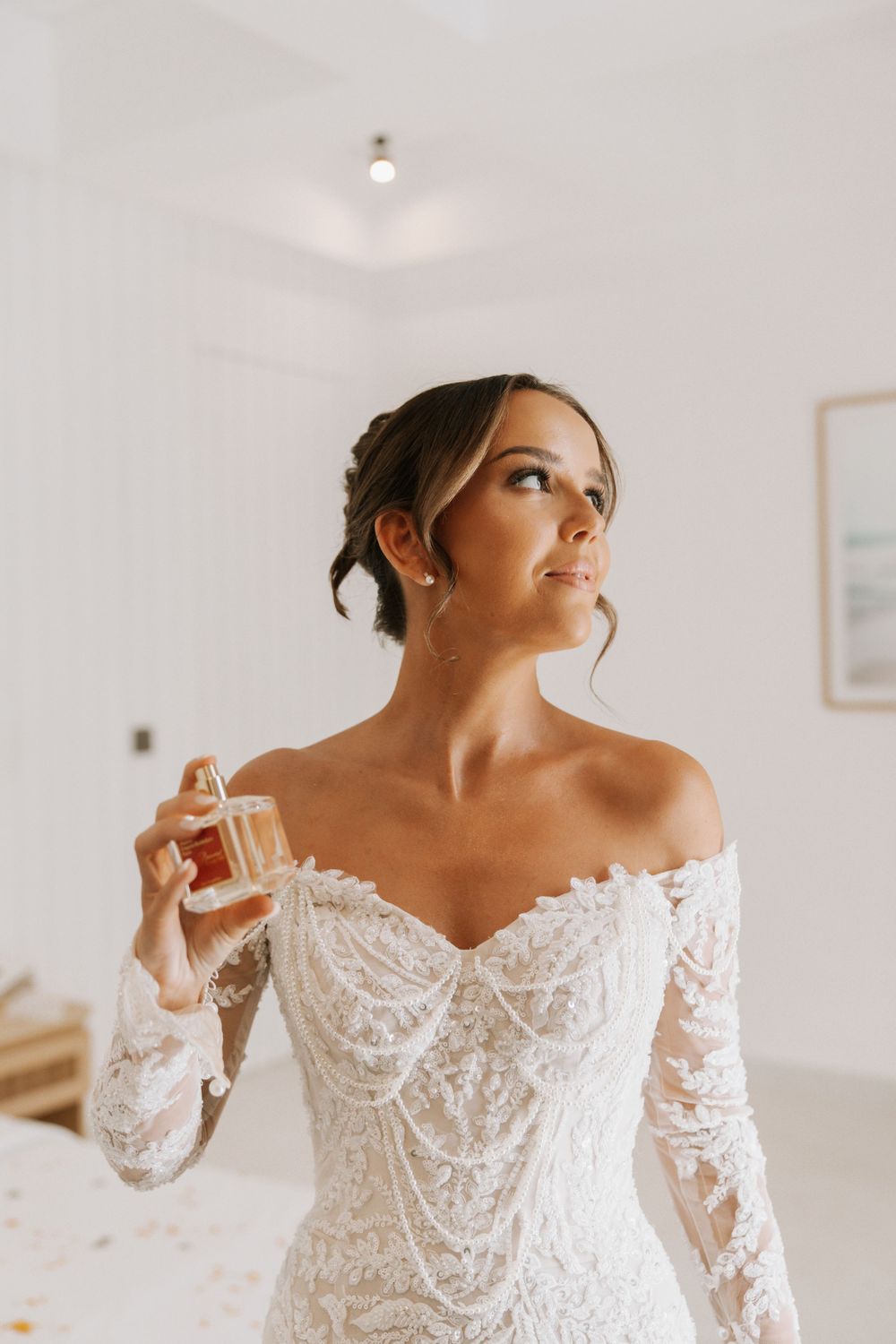 A detailed sequence of wedding gown shots showing intricate lace sleeves and off-shoulder neckline in a bright white room.