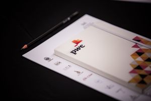 Professional business stationery and branding materials laid out on dark surface.