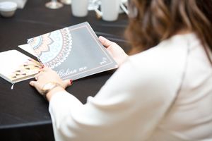 Close-up of hands holding business documents on dark table.
