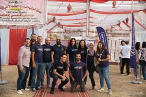Professional team photo at outdoor event with red and white tent backdrop.