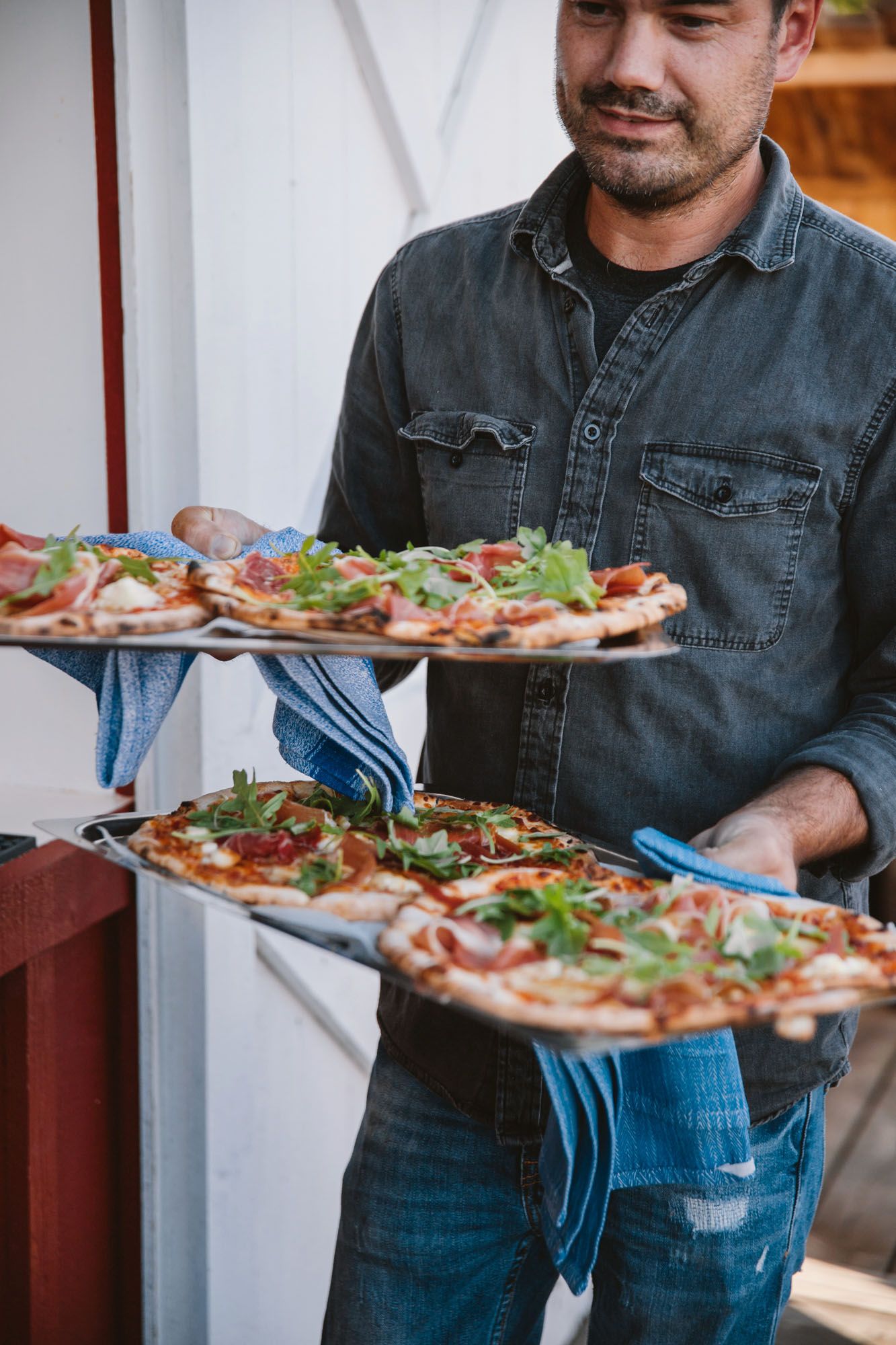 Kock som serverar nygräddade pizzor på bröllopsfest i Fiskebäckskil
