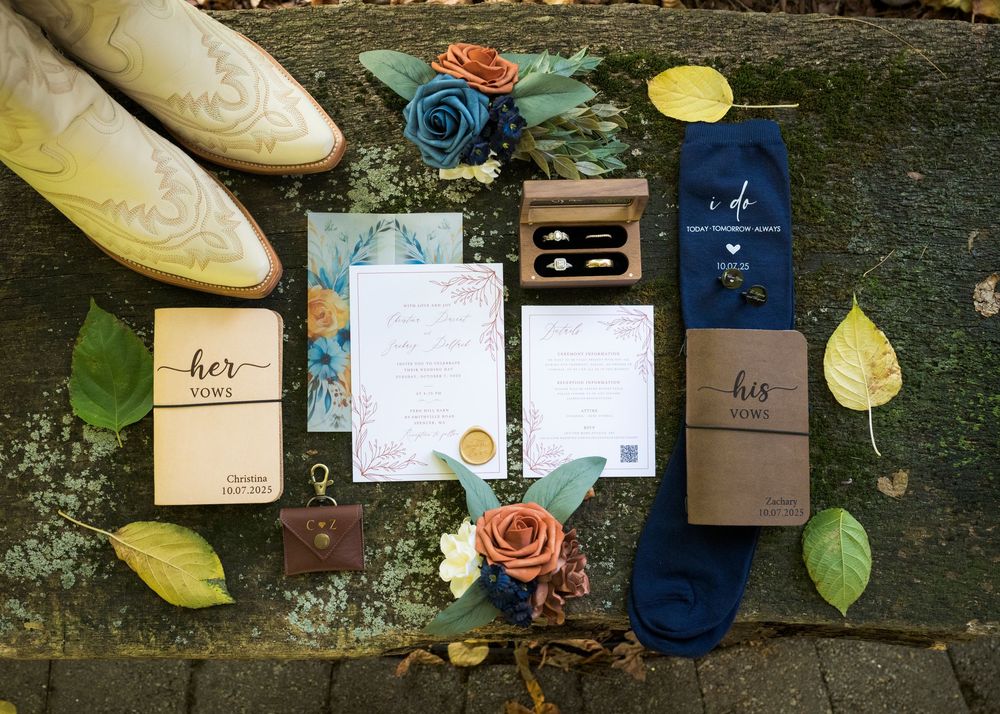 Wedding stationery and decorative elements arranged on rustic wooden surface.