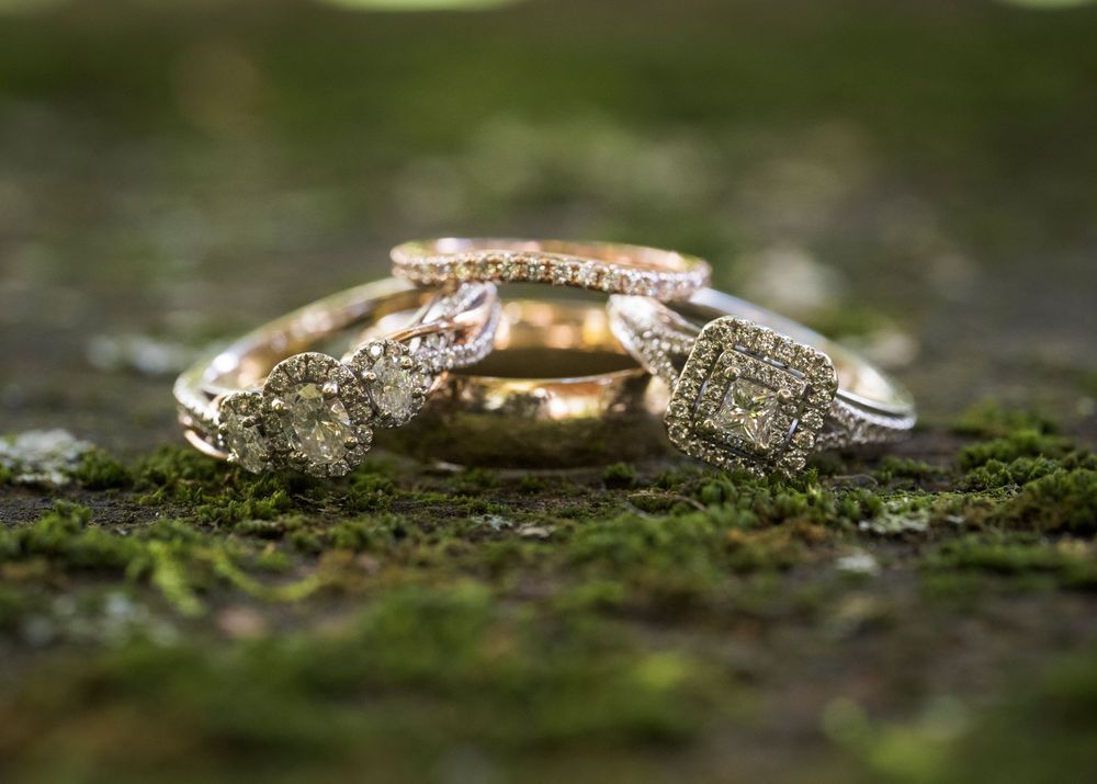 Macro shot of wedding rings on mossy natural surface with shallow depth of field.