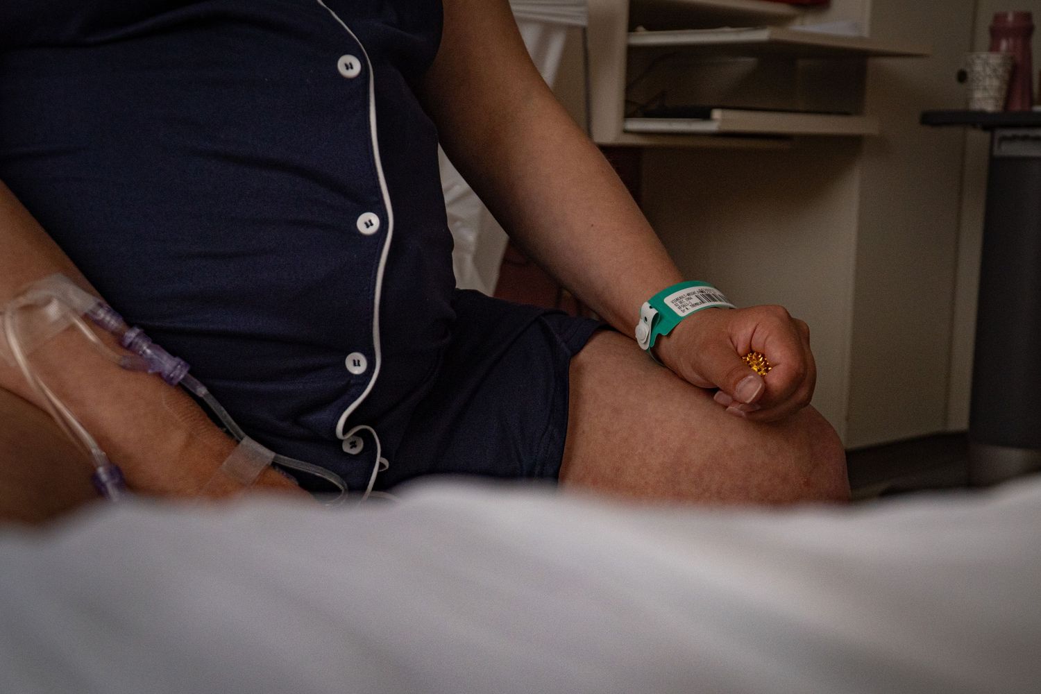 Close-up of a patient's hand with hospital ID bracelet and IV line during labor.
