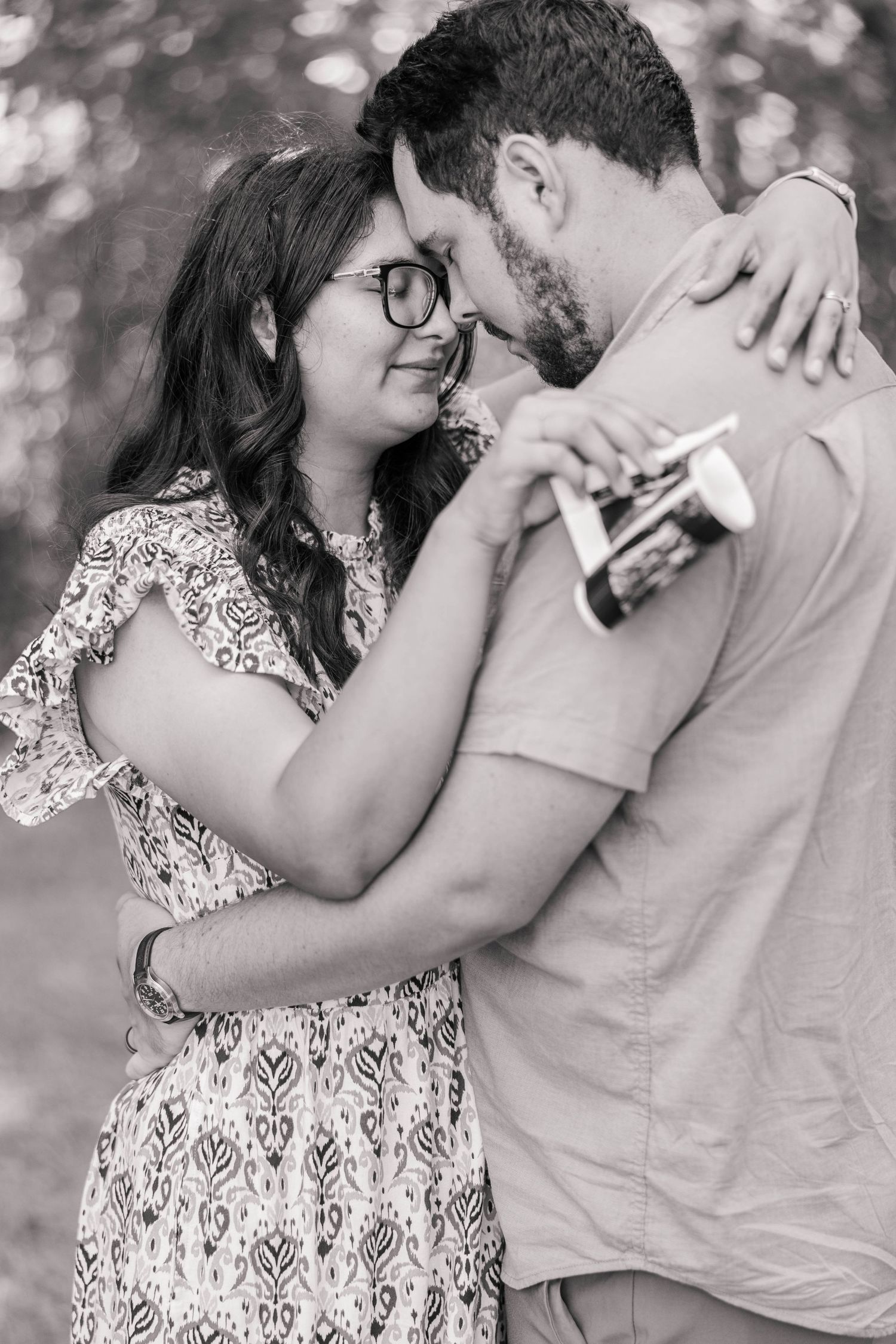 A romantic black and white photo series showing a couple in an intimate embrace, smiling and laughing together.