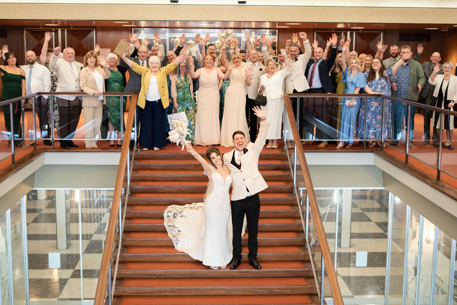 A panoramic sequence showing a bridal party walking down grand stairs in a cruise ship atrium.