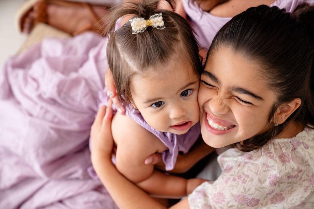 Sweet candid moments of family bonding and laughter in matching purple and cream colored outfits.
