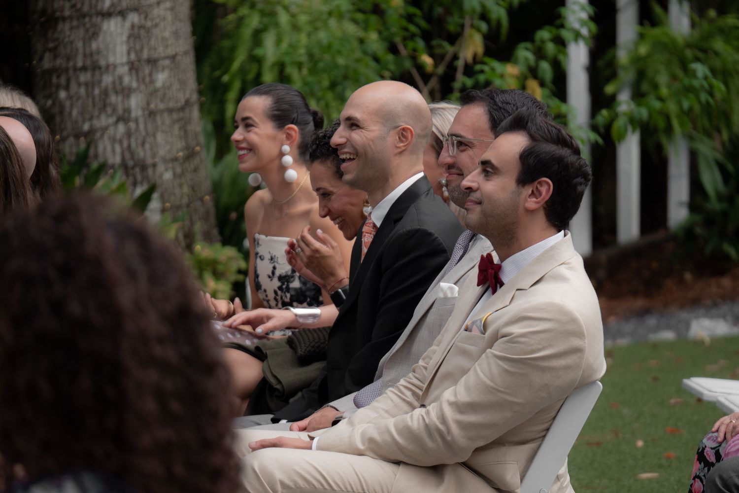 Wedding guests laughing and enjoying themselves during an outdoor reception.