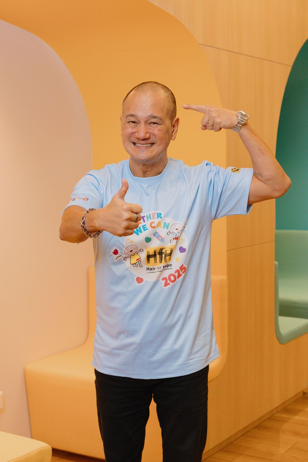 Person in light blue t-shirt making playful dance poses against orange wall background in sequence of four shots.