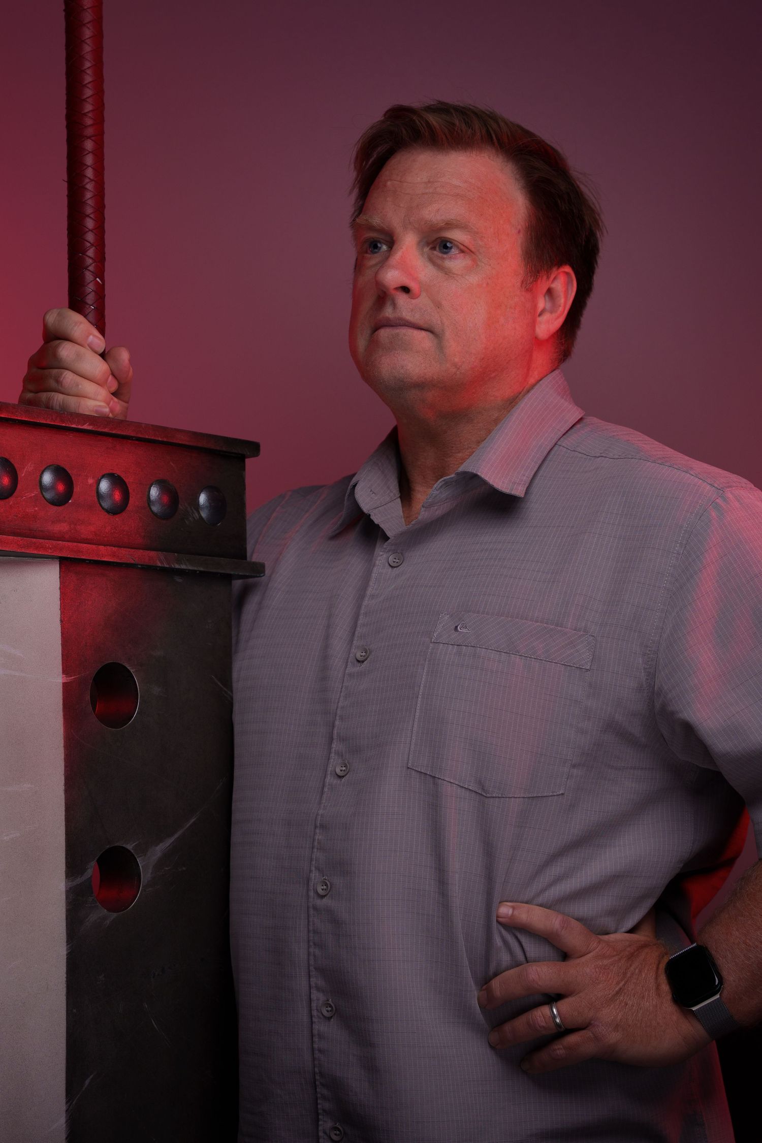Professional studio portraits with moody red lighting and dramatic side angles.