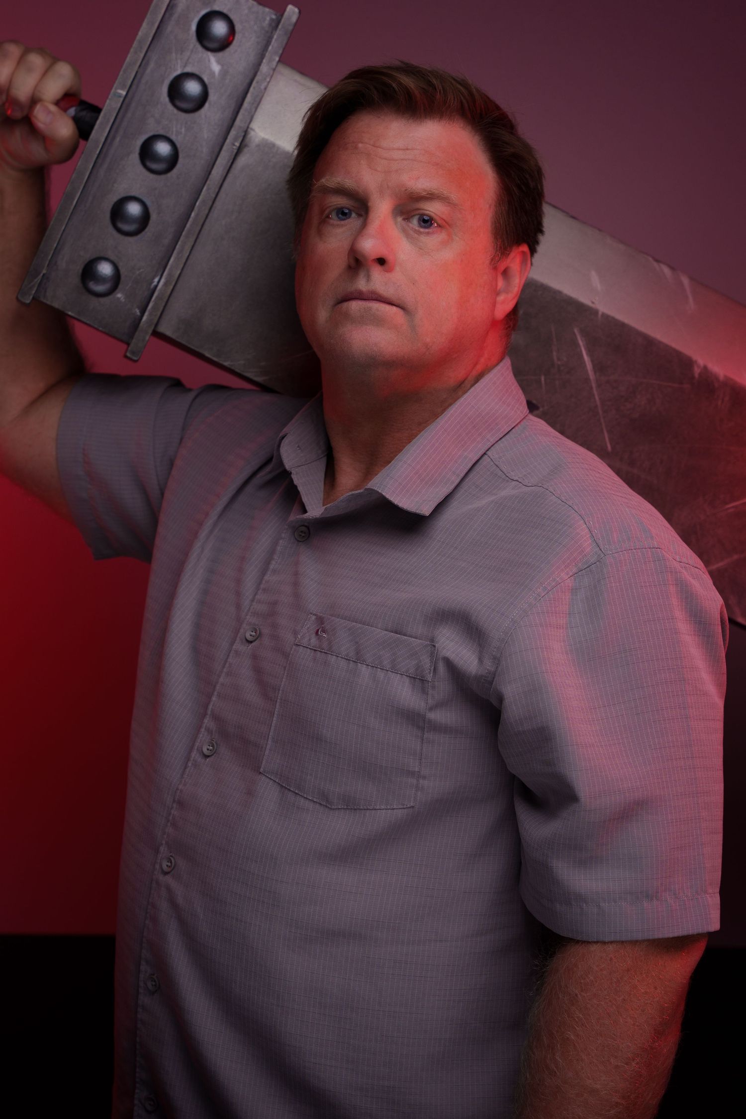 Dramatic red-lit studio portraits with industrial backdrop elements.