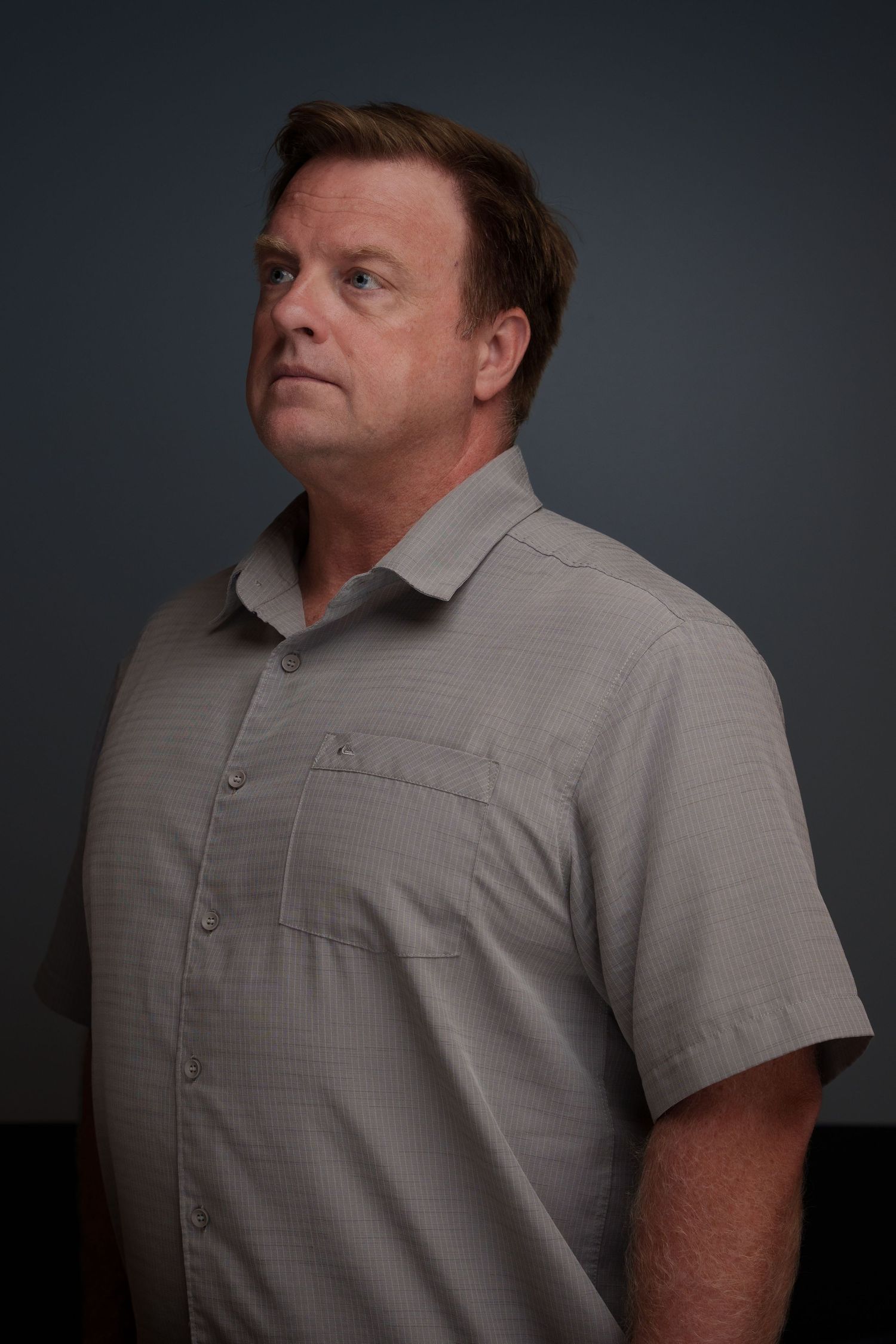 Studio portraits against dark backdrop showing different poses in casual gray attire.