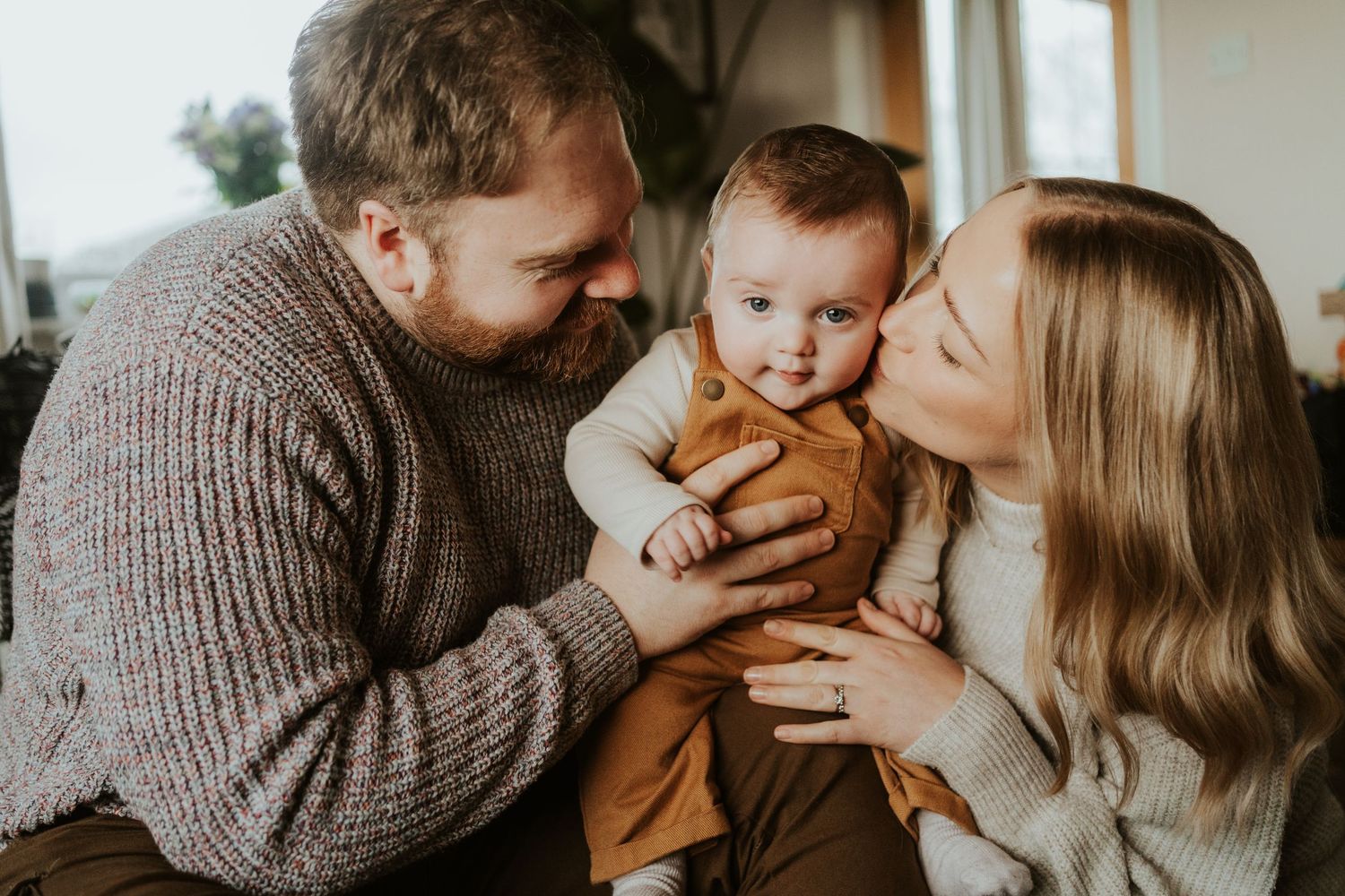 Cozy indoor family photo session featuring warm neutral tones and intimate moments together.
