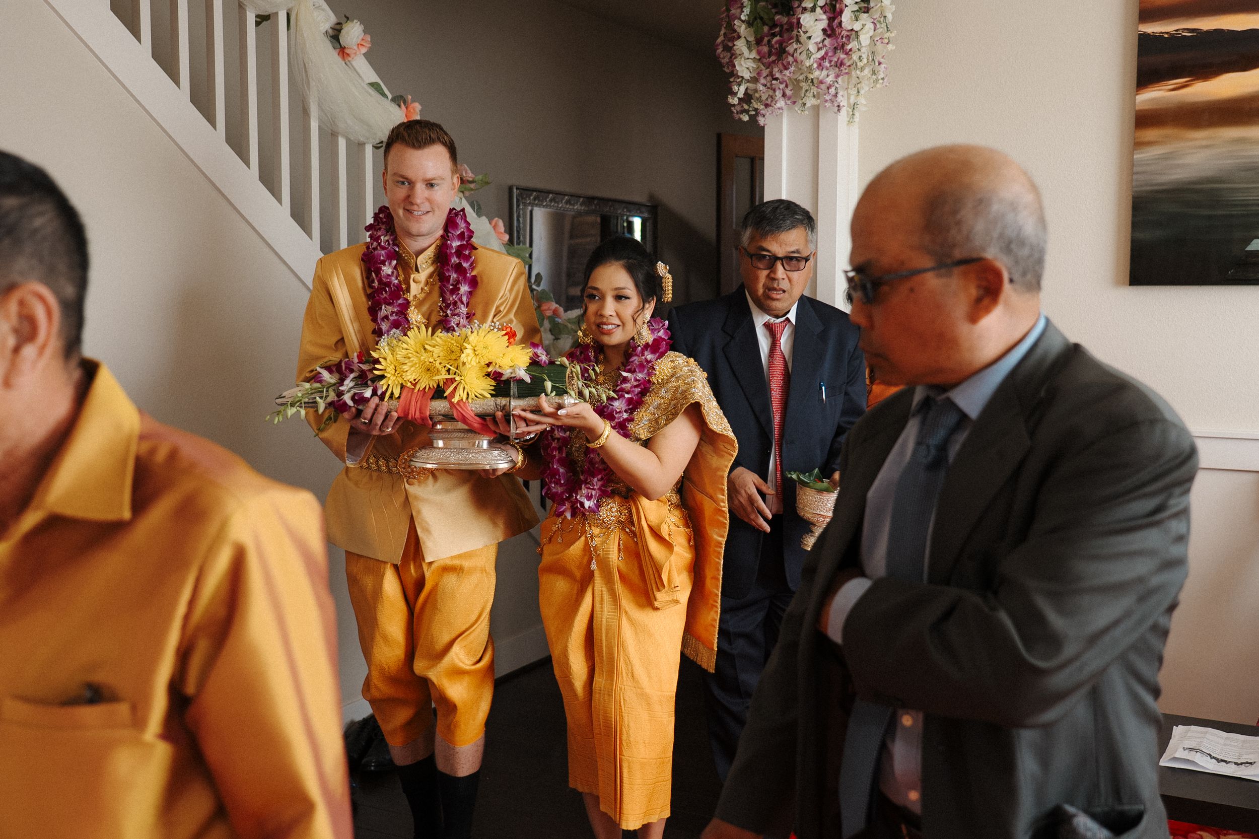 Wedding party members in yellow dresses gather together in an elegantly decorated room during a celebration.