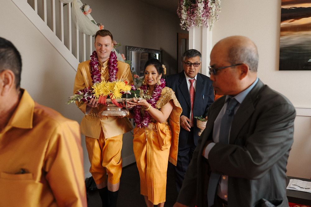 Wedding party members in yellow dresses gather together in an elegantly decorated room during a celebration.