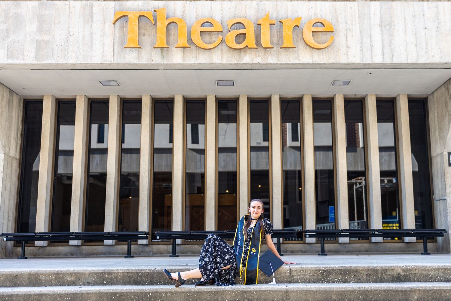 Large theatre building with white columns and signage above entrance showing 'Theatre' text in gold lettering.