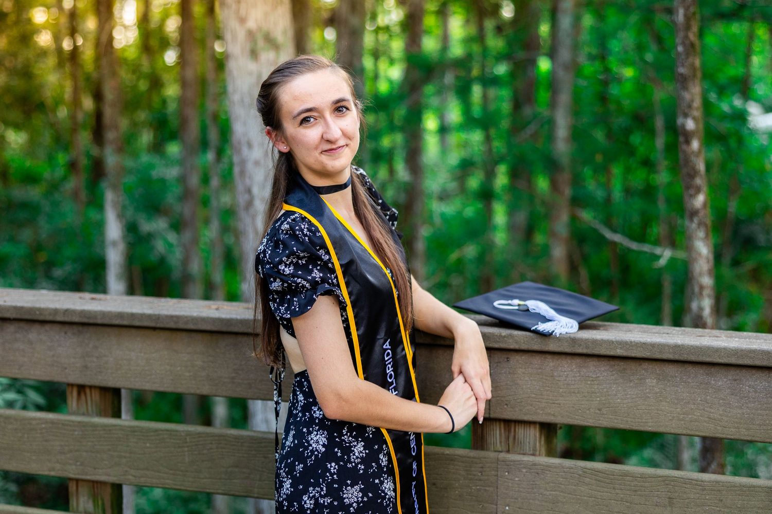 Graduation portraits taken in a wooded setting with natural greenery.