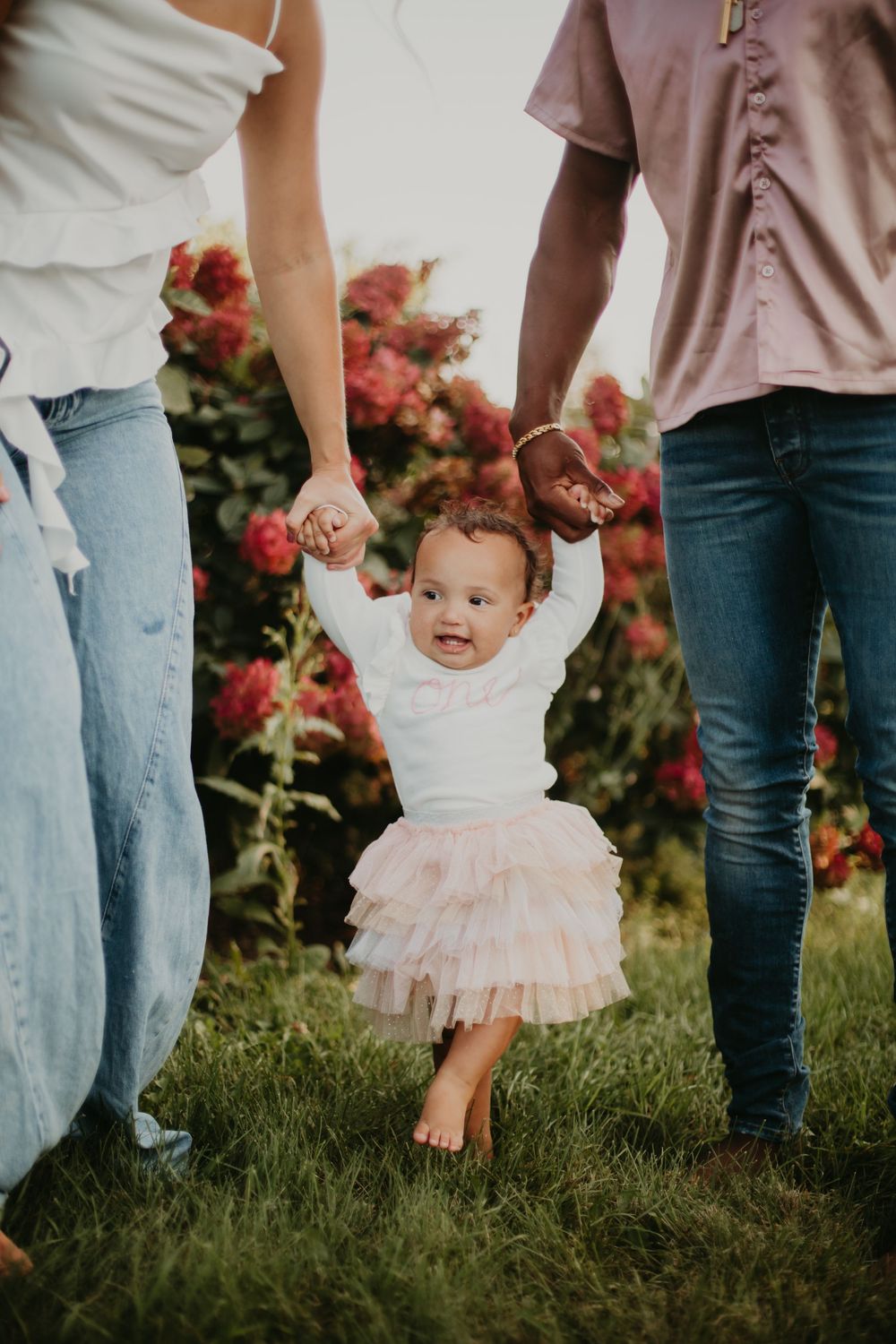 Sequence of images showing child in pink tutu holding hands with parents in garden setting with blooming roses.