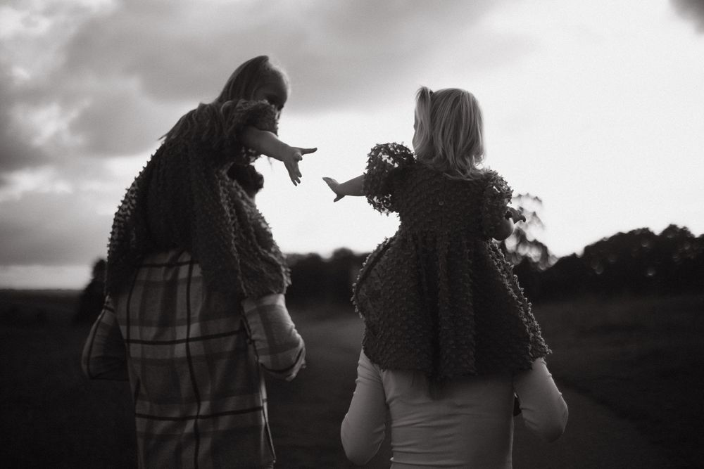 Silhouettes of two people walking together at sunset in a romantic black and white scene.