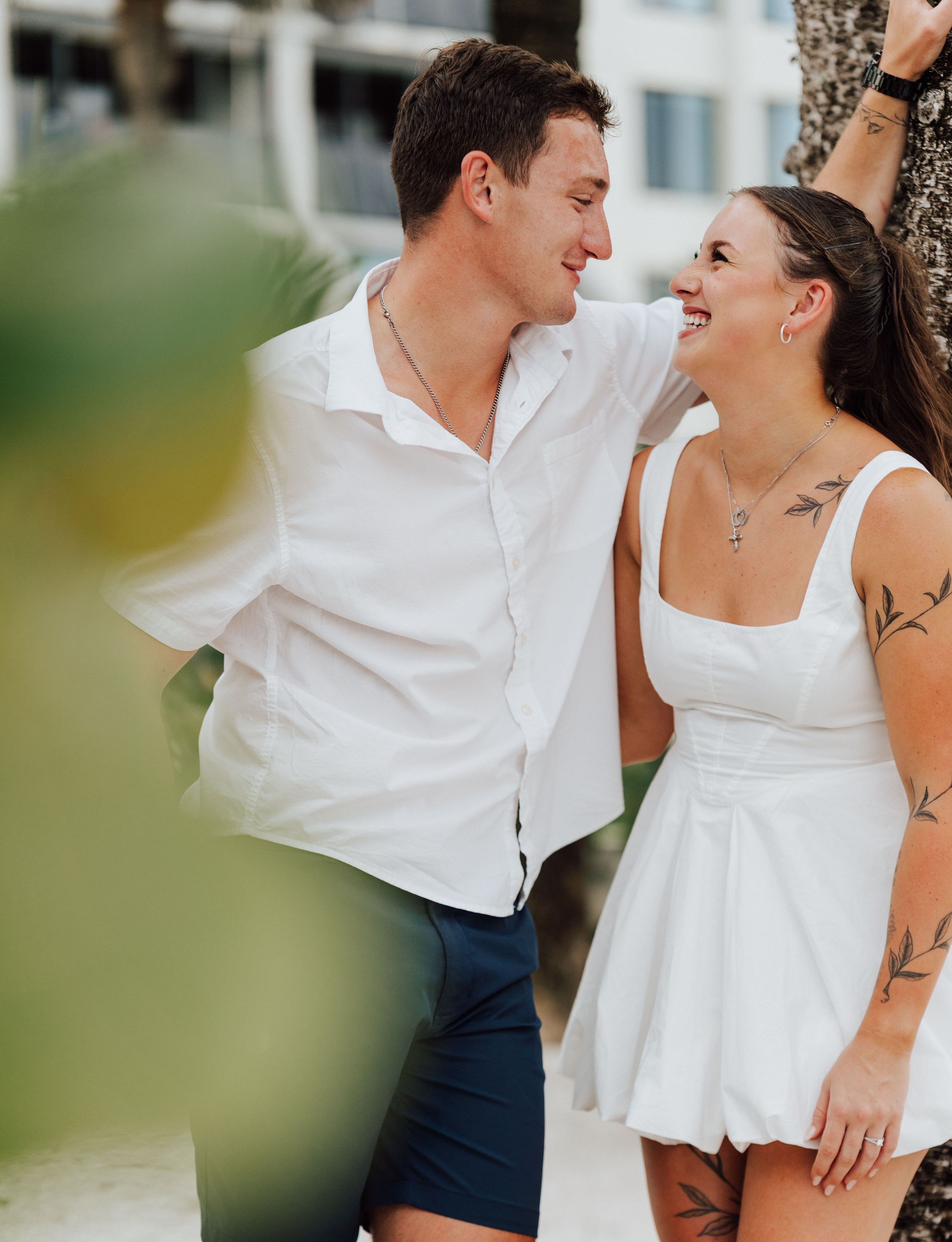 Elegant engagement portraits by palm trees and reef at St. Pete Beach, Florida during golden hour.