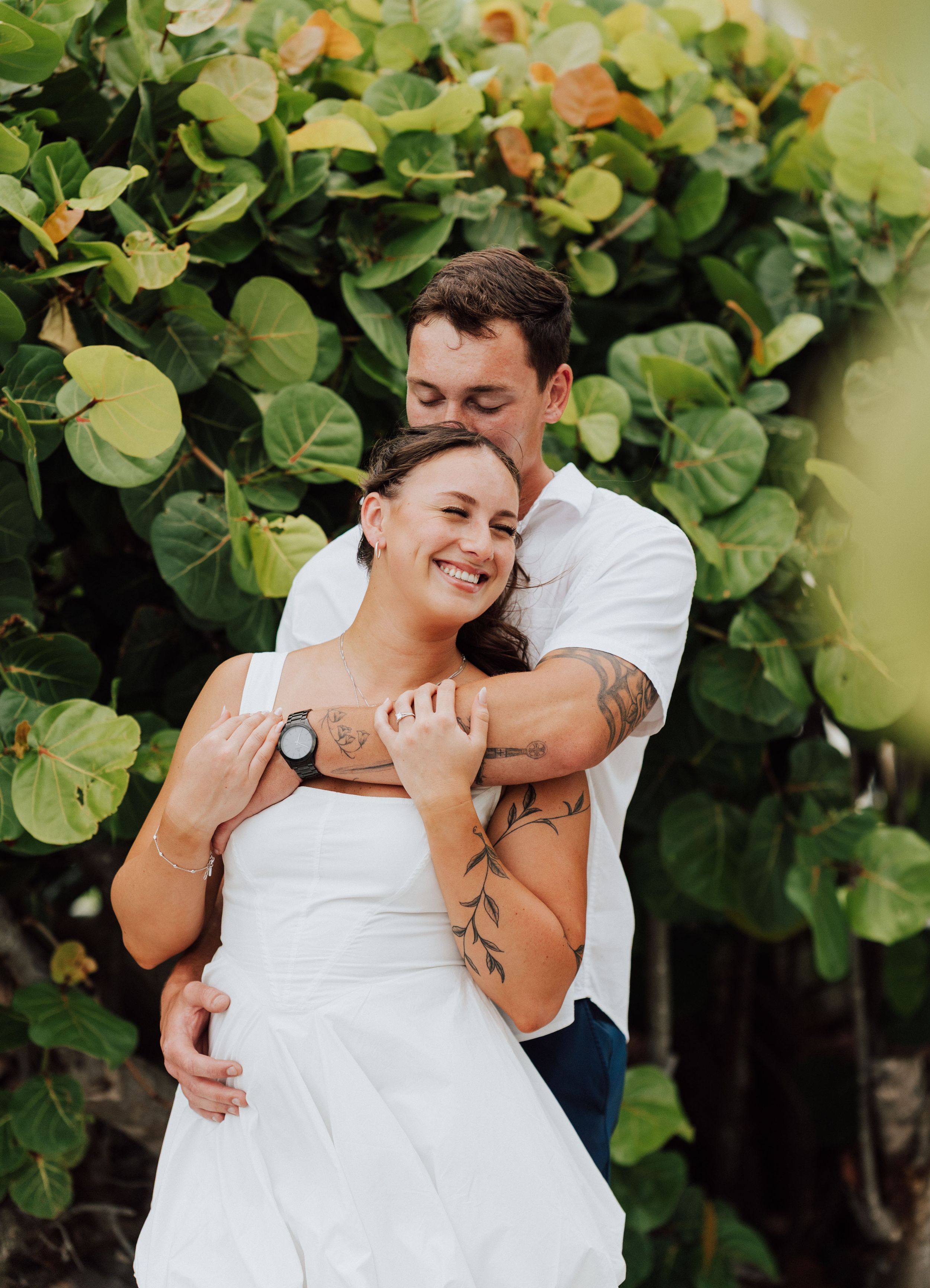 Elegant engagement portraits by palm trees and reef at St. Pete Beach, Florida during golden hour.