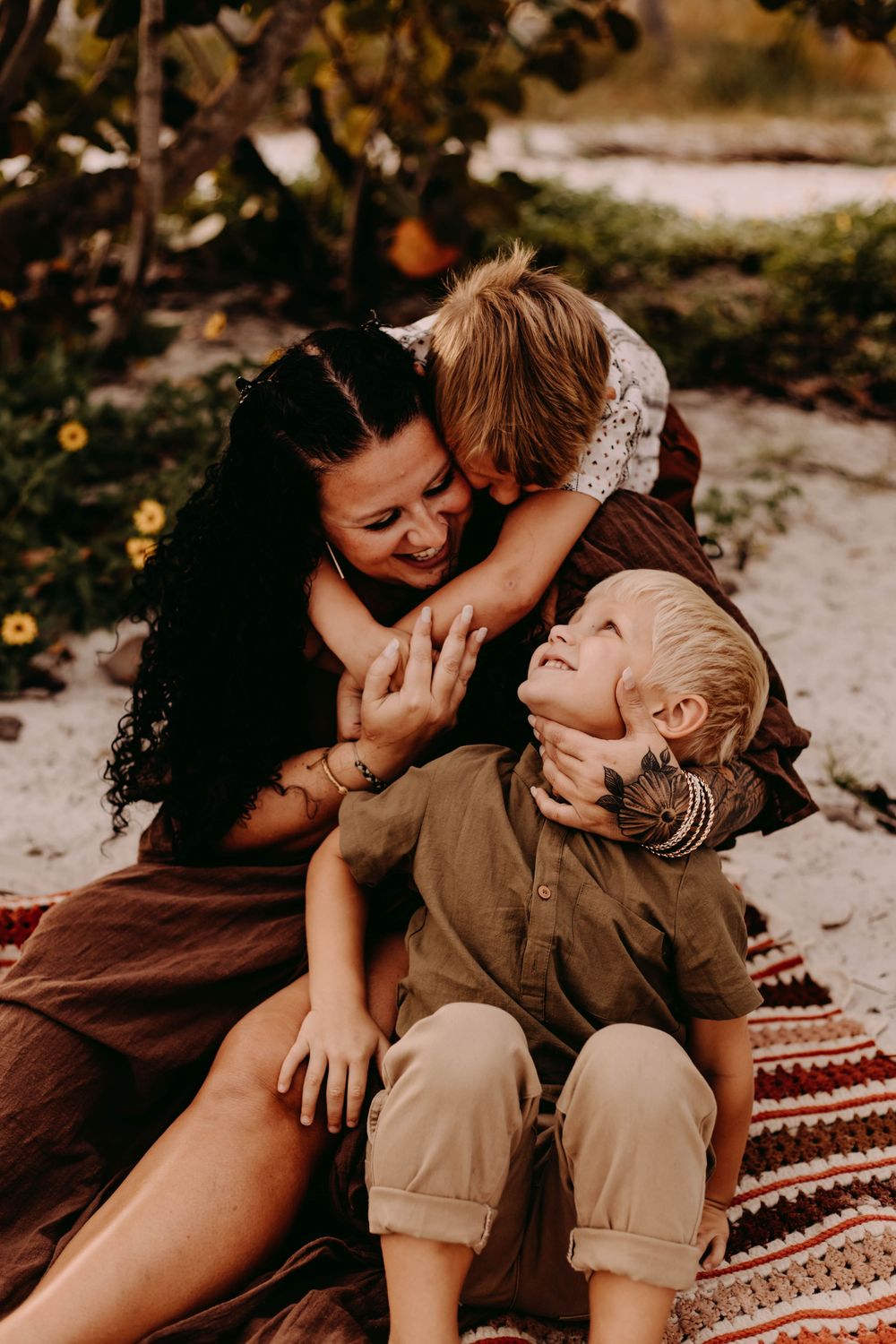 A series of candid photos showing tender moments between a parent and child on a blanket outdoors at sunset.