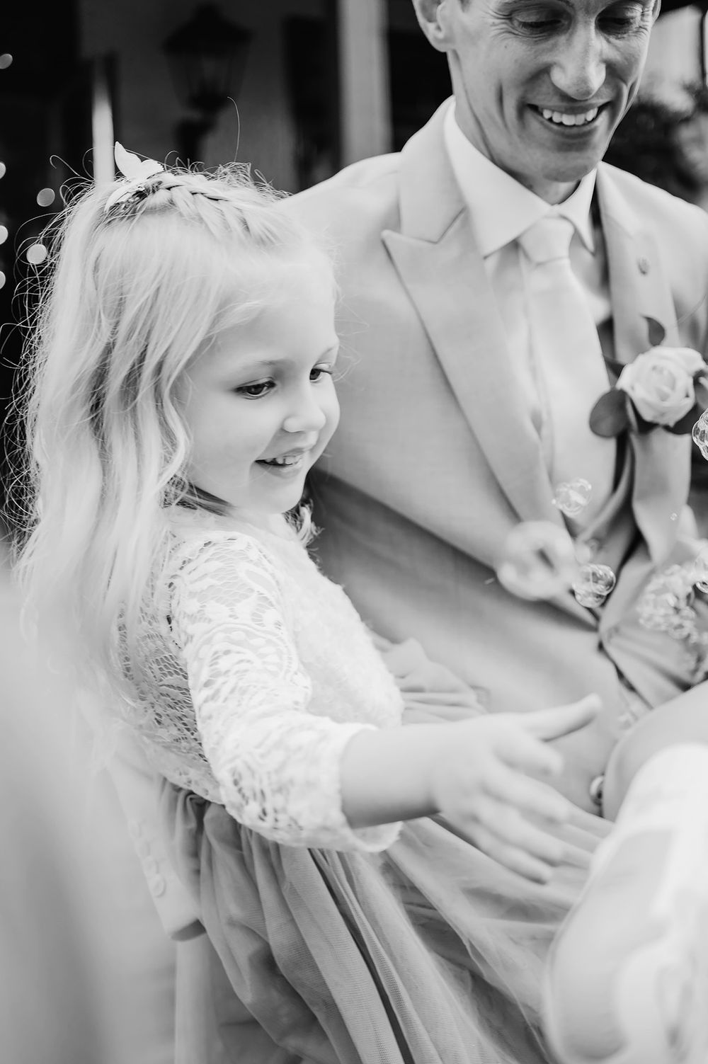 Brudgummen håller i sin lilla dotter i famnen under bröllop i Borensberg på Ångbageriet. Bröllopsfotograf Josefin Landhagen.