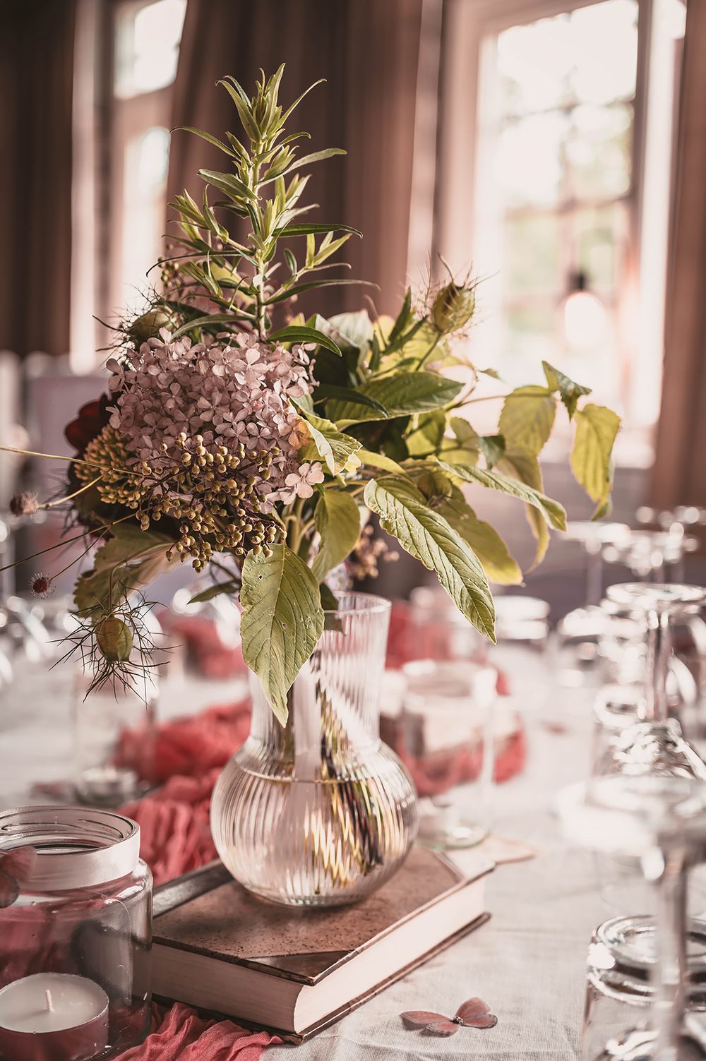 Bröllopsdukning med blomsterarrangemang på Ångbageriet i Borensberg. Detaljfoto av bröllopsfotograf Josefin Landhagen i Östergötland.