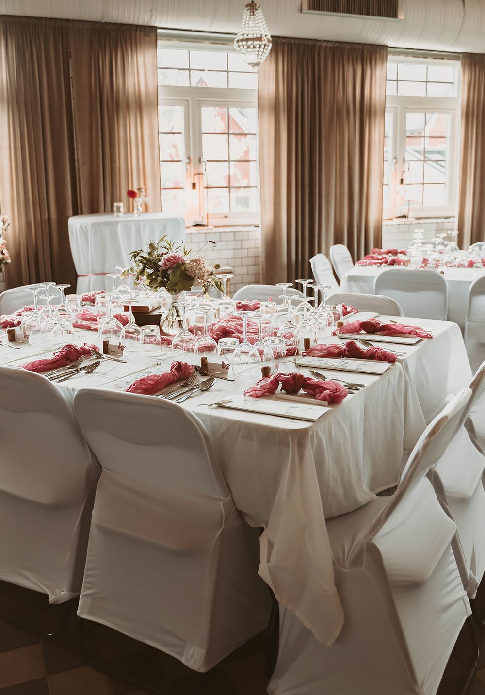 Bordsdukning i vitt med rosa detaljer på bröllop på Ångbageriet i Borensberg. Foto: bröllopsfotograf Lets Bloom Media.