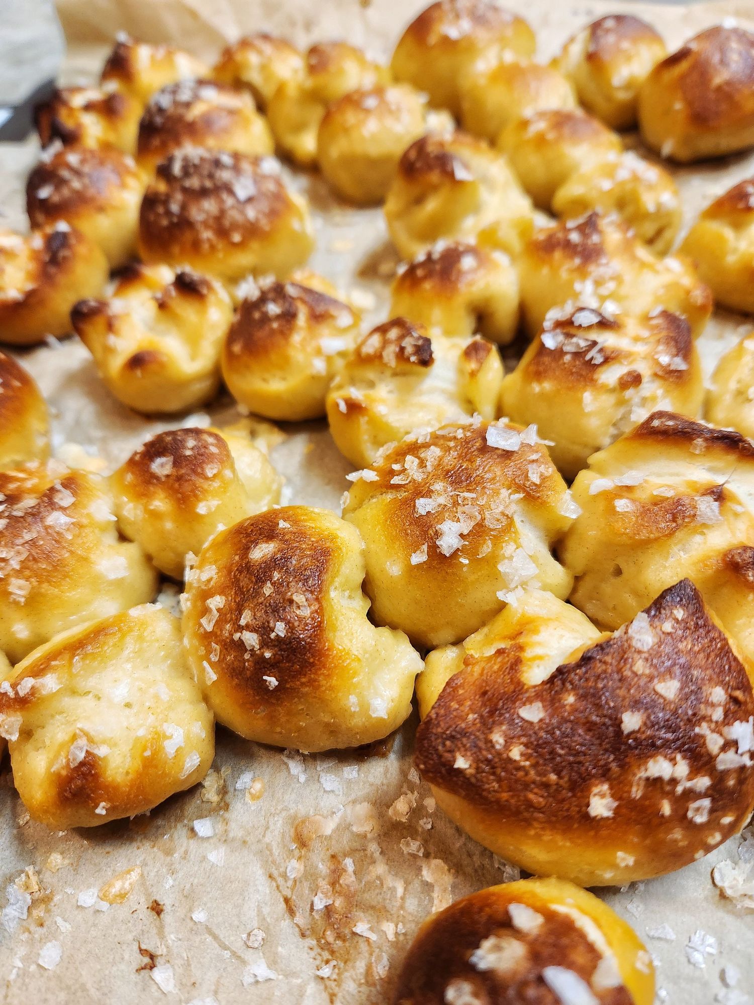 Freshly baked soft pretzel bites with coarse salt sprinkled on top showing golden brown color and texture.