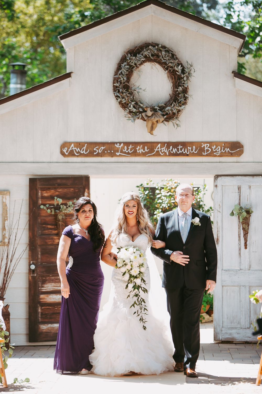 Rustic barn wedding venue with white walls and wreath decorations shown in a series of elegant ceremony photos.