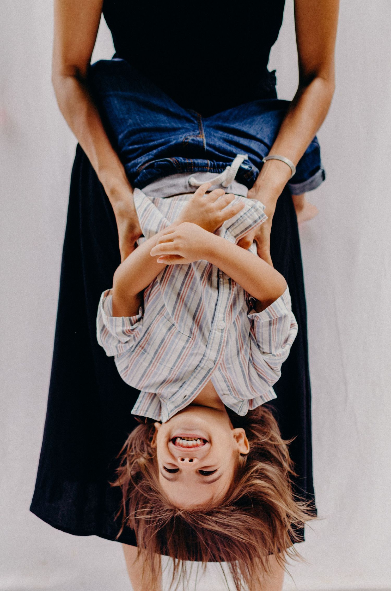 Playful upside-down portrait showing pure joy and laughter.