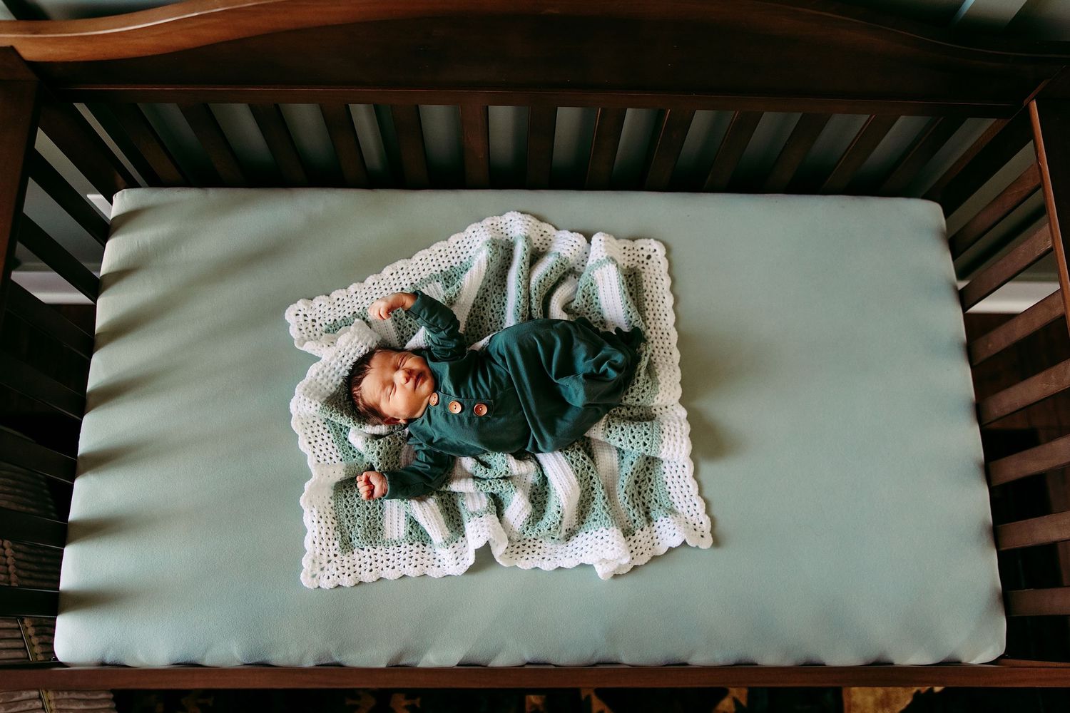 Lifestyle newborn photography in a baby’s nursery using natural light and neutral tones