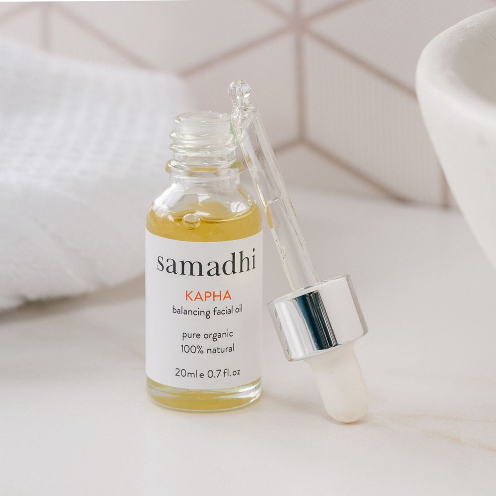 Product photography of luxury skincare oil bottle styled in a bathroom setting