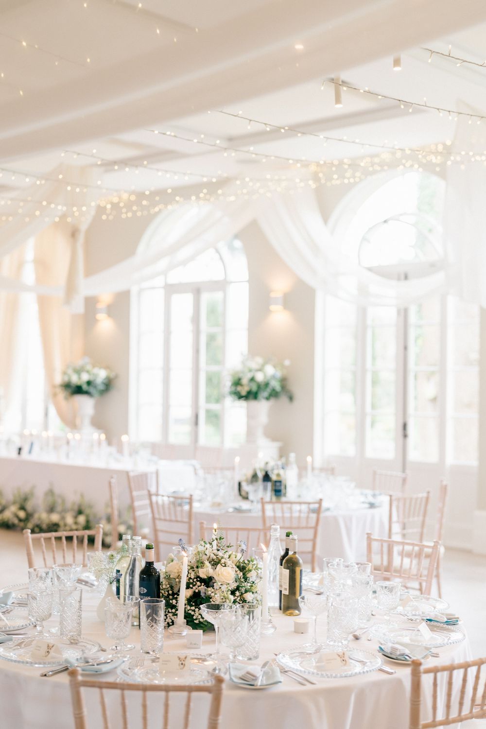 Event and venue photography of a wedding reception room with round tables and florals