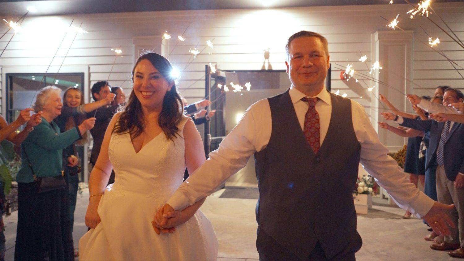 A wedding reception dance floor filled with guests dancing and celebrating under indoor lighting.