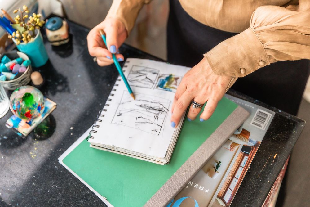 Close-up shots of hands working on artistic sketches and materials on a green surface.