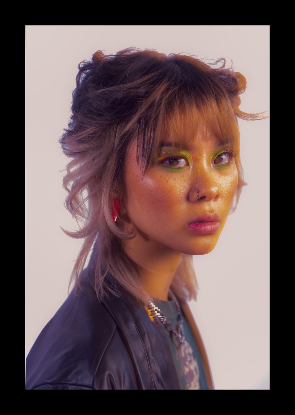 Close-up portrait with dramatic lighting and bright pink lipstick.