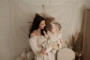 A series of soft, neutral-toned maternity and newborn photography portraits against white backdrops.
