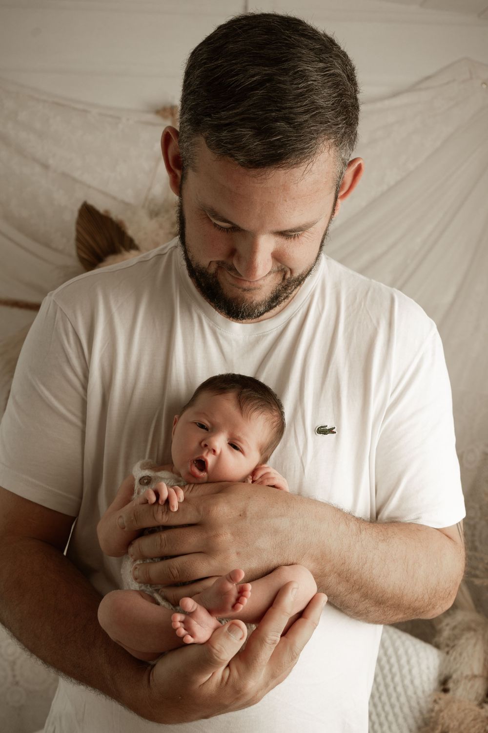 A tender moment between parent and newborn baby captured in a series of black and white photographs.