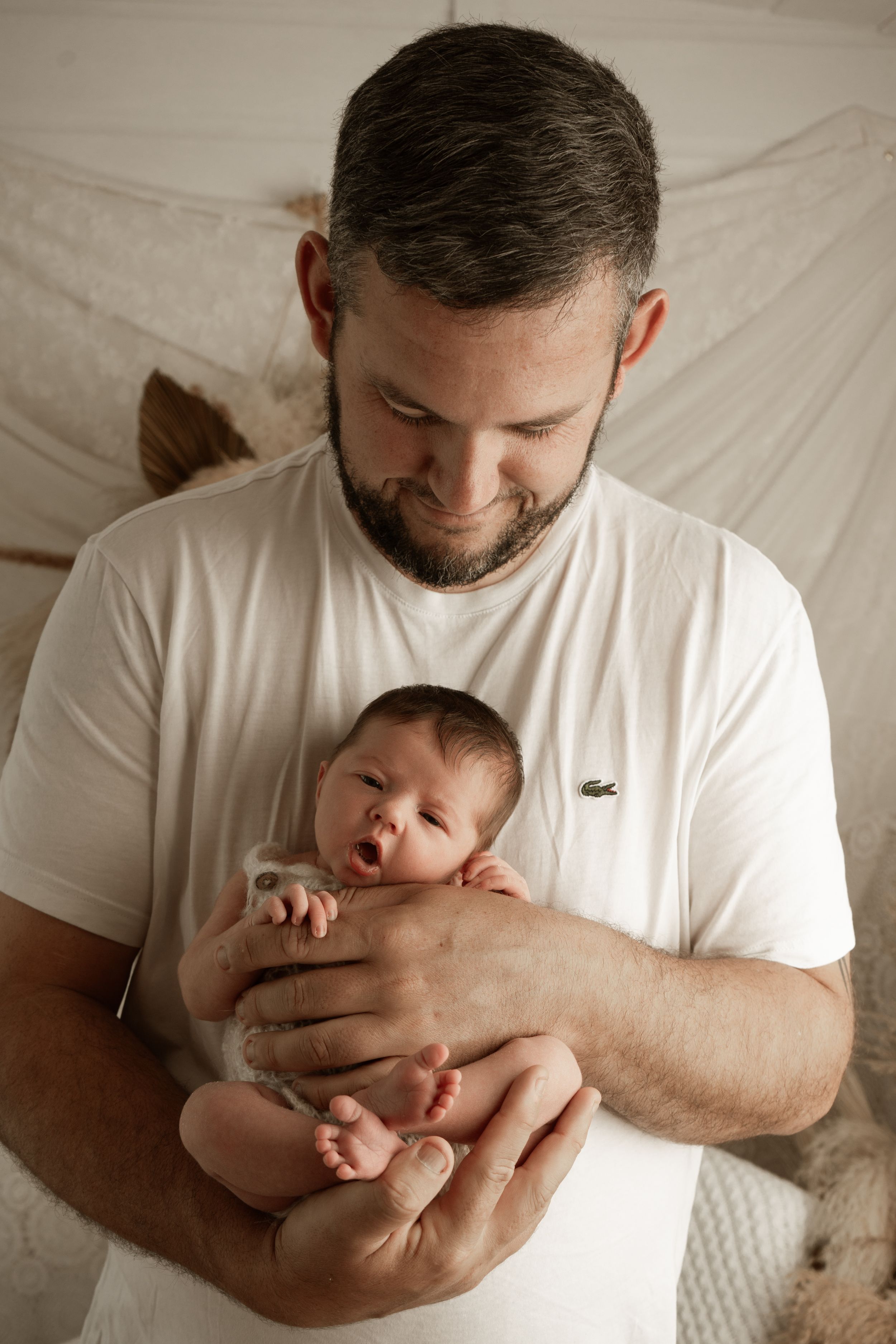 A tender moment between parent and newborn baby captured in a series of black and white photographs.