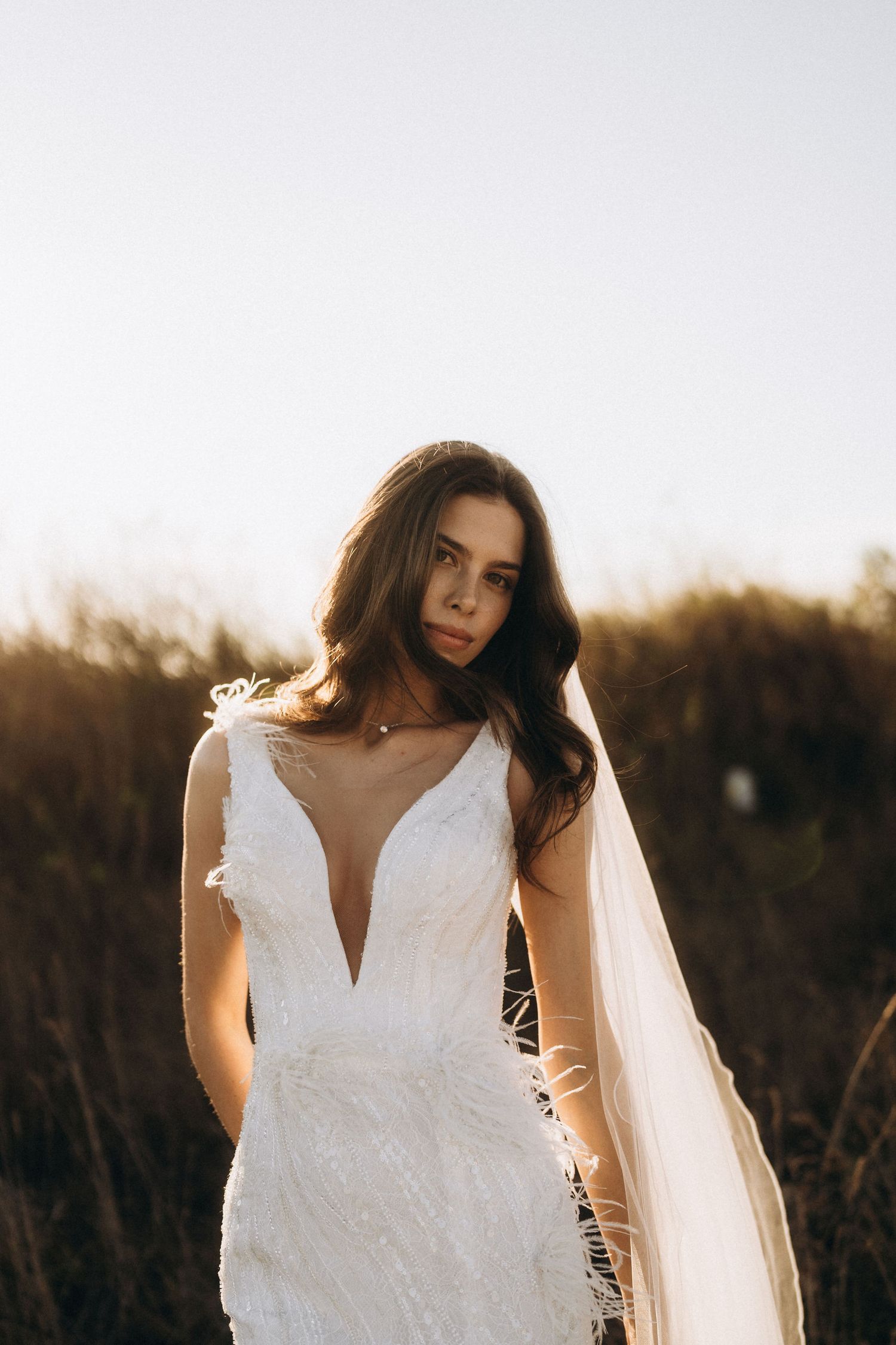 Outdoor bridal portraits featuring a white wedding dress with plunging neckline.