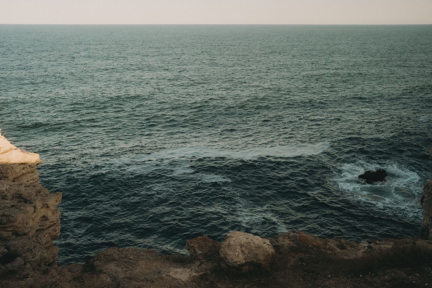 Panoramic view of rocky coastline and deep blue ocean waters.