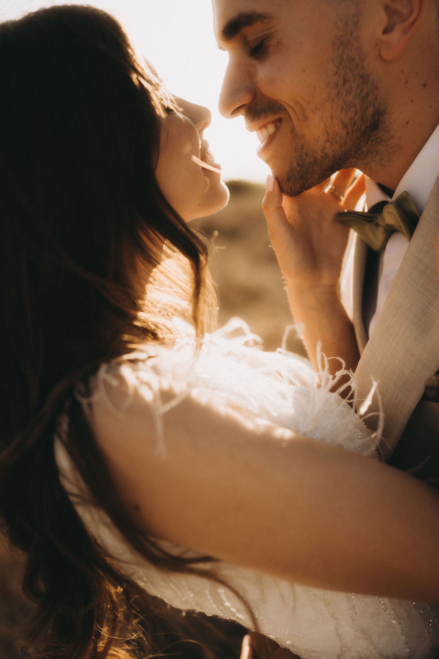 Intimate close-up of couple in wedding attire during golden hour.