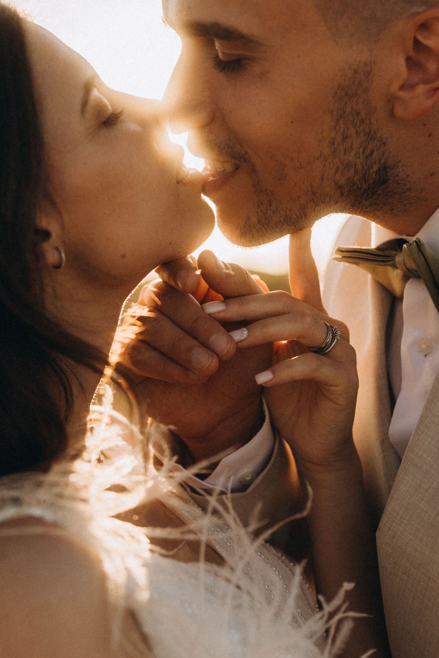 Sunlit wedding portraits capture intimate moments between a couple in warm golden light.